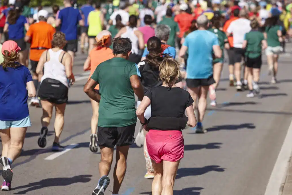 Corredor durante treinamento para maratona, ilustrando como o volume e a frequência de treino influenciam o desempenho esportivo segundo evidências científicas.