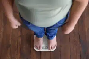 Obesidade infantil na primeira infância: médico avaliando o crescimento e o estado nutricional de uma criança com participação da família.